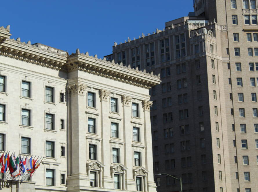 Neoclassical building with global flags in front of modern towers — symbolising SME strategy and growth